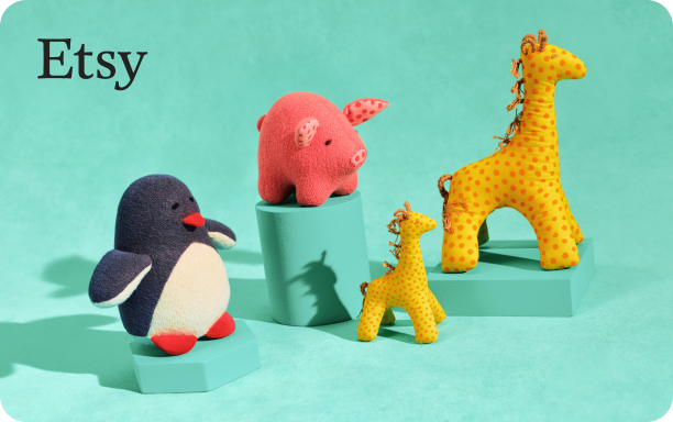 Still life photograph of plush toy animals on a teal background. On the left, a penguin with a white belly, black body and red feet. In the centre, a pink pig with darker pink details sits atop a teal block. To the right, two giraffes - one large with yellow fabric and orange spots, and a smaller one with lighter yellow and orange spots - stand near each other, with the smaller giraffe in front of a shorter teal block.